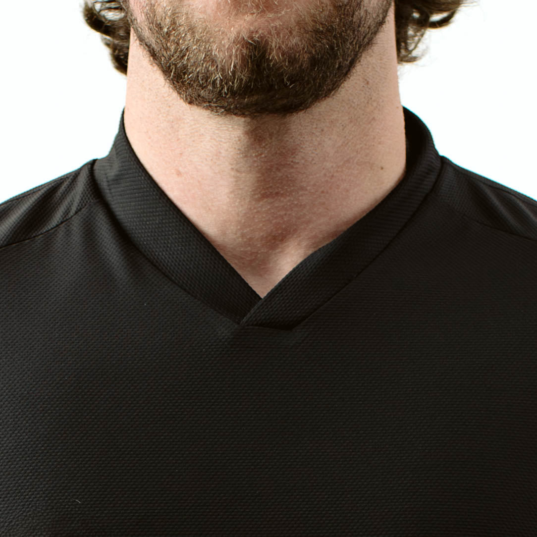 Close up of TD OSS Top V2 Long Sleeve in Black showing updated V shaped collar designed to protect against sling rub and hot brass, lightweight tactical combat base layer operator top built for range training, shooter use, and duty wear under plate carriers