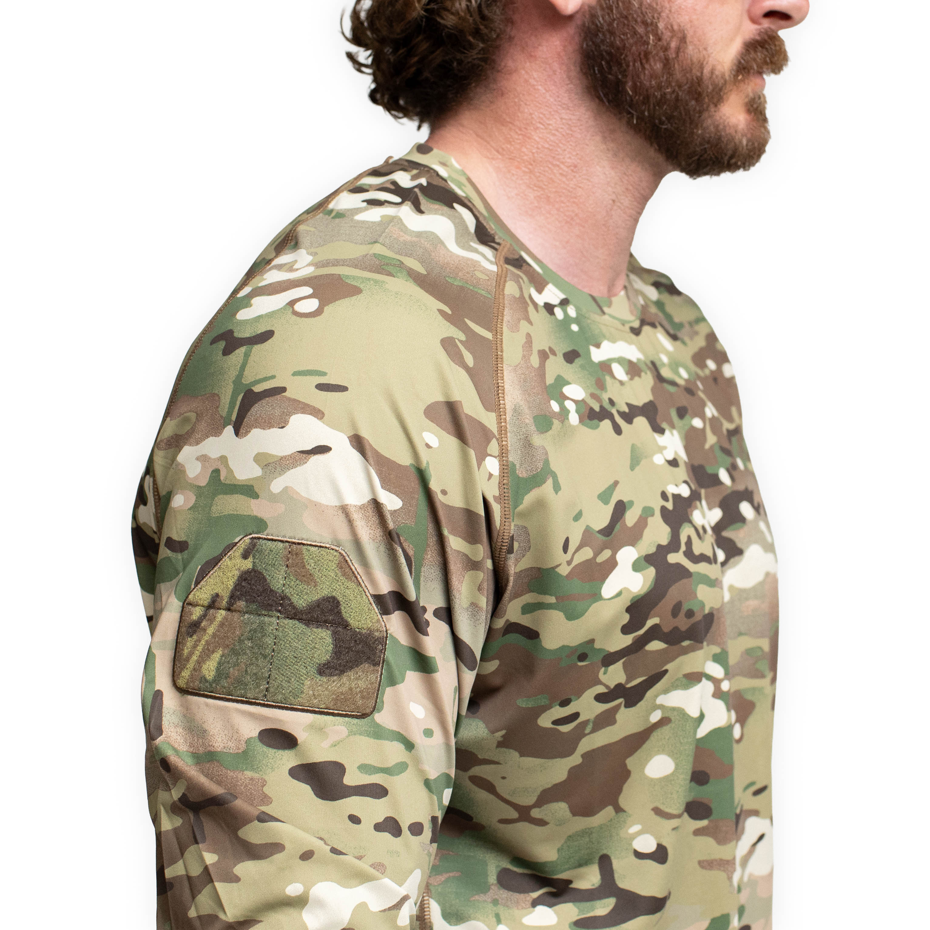Three quarter detail view of the TD Shooter Shirt MultiCam long sleeve highlighting the MIL SPEC loop bicep patch, tonal flatlock seams, and durable 4 way stretch performance fabric engineered for tactical training, range sessions, and professional field use. Offered by Tactical Distributors in Virginia Beach for users across the United States.
