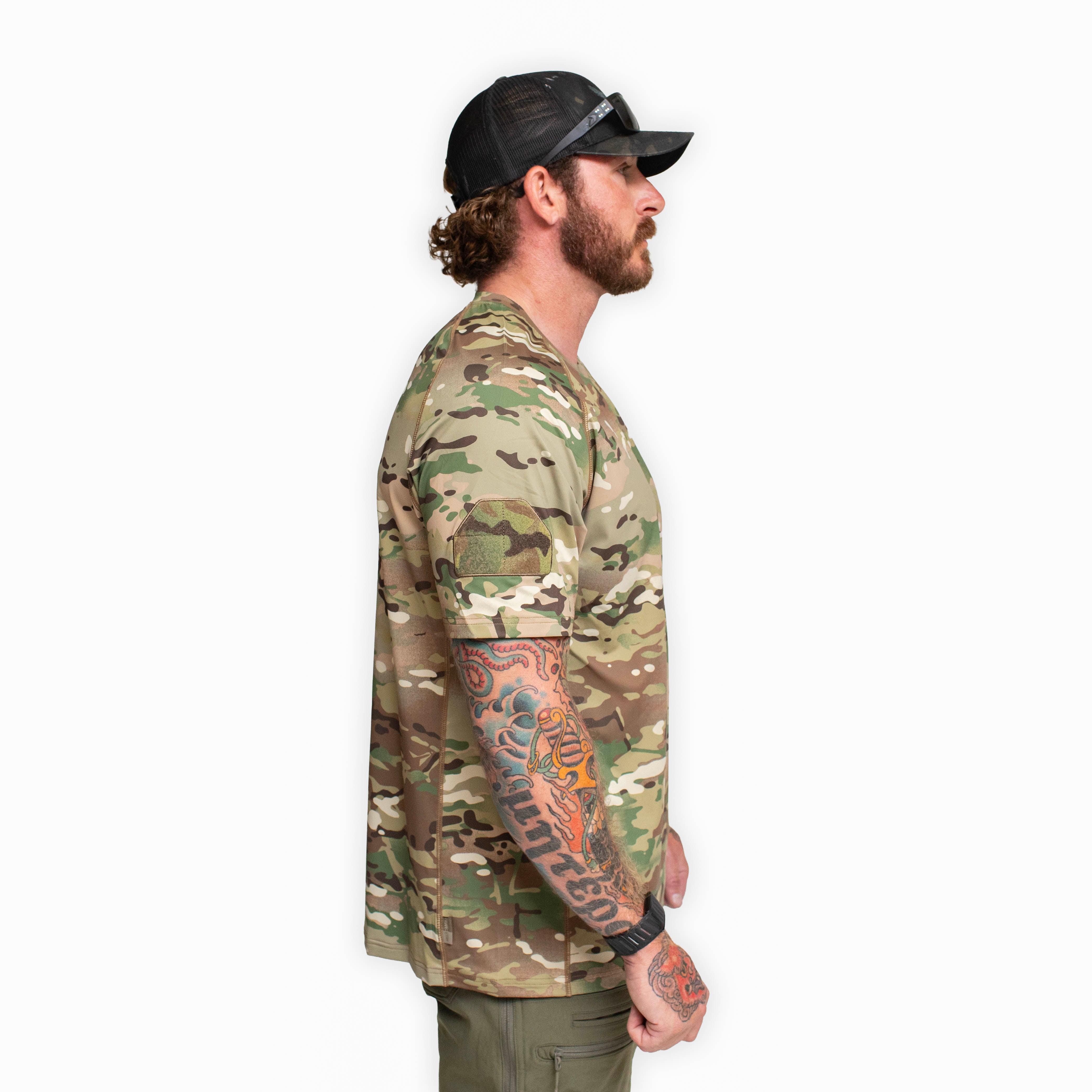 Side profile of the TD Shooter Shirt MultiCam short sleeve showing the raglan sleeve construction, breathable 4 way stretch fabric, and MIL SPEC loop patch placement designed for unrestricted movement during training and field use. Distributed by Tactical Distributors in Virginia Beach and available to tactical users across the United States.