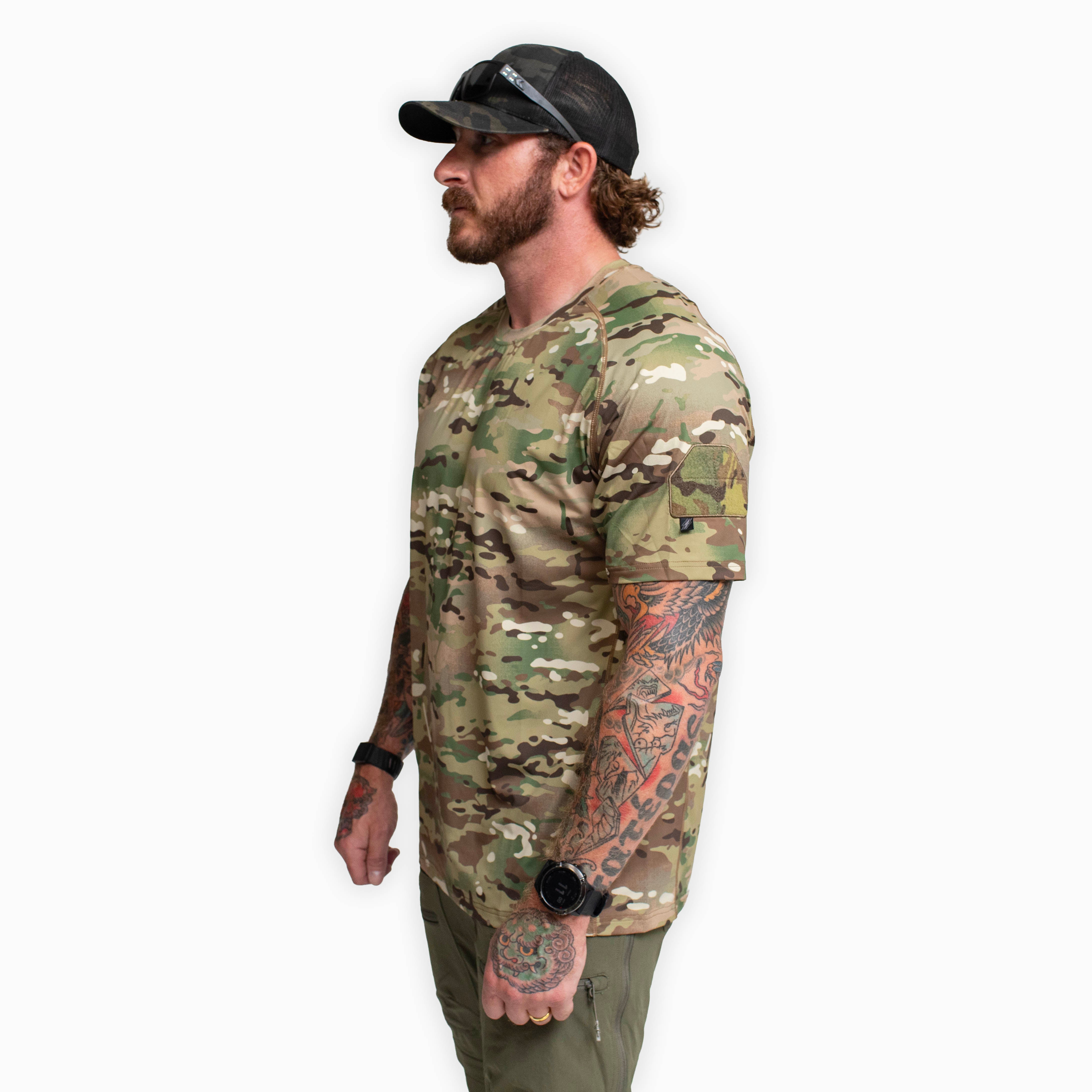 Side view of the TD Shooter Shirt MultiCam short sleeve version showing the athletic cut, wrapped side body panels, raglan sleeve construction, and MIL SPEC MultiCam loop bicep patch designed for mobility and comfort during range training and tactical movement. Available from Tactical Distributors for shooters and outdoor professionals across the United States.