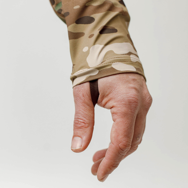 Close-up of the MultiCam TD Outdoor Tiger Shark Sun Shirt 3.0 showing UPF 50 fabric, flatlock stitching, and thumb loop for tactical sun protection and performance fit.