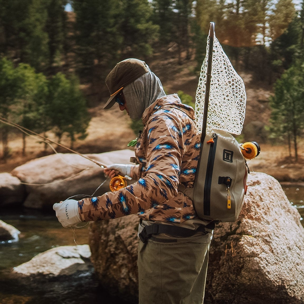 TD x Black Canyon Systems Southwest Tan tactical sun hoodie worn during fly fishing on open water, breathable quick dry performance shirt with UV protection designed for hot weather outdoor pursuits and long hours under direct sun