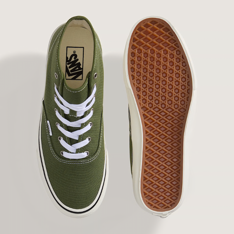 Green Vans sneakers with white laces on a light gray background