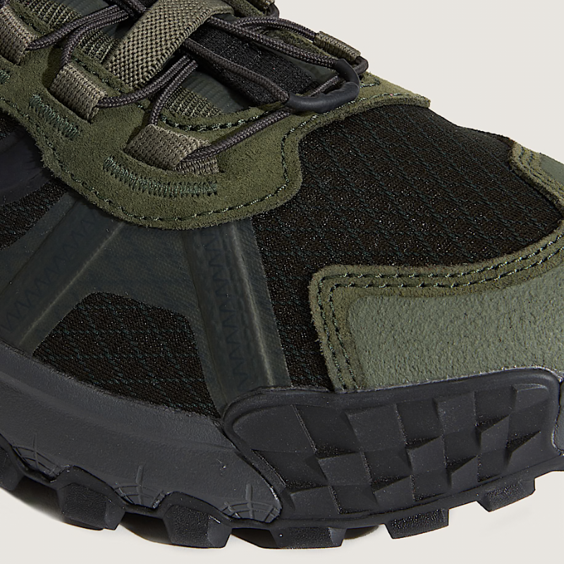 Close-up of a green and black hiking shoe with textured sole
