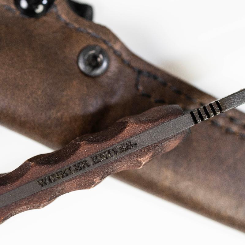 Close up of Winkler Knives maker mark etched on 80CrV2 black oxide fixed blade highlighting American made craftsmanship and tactical field knife construction
