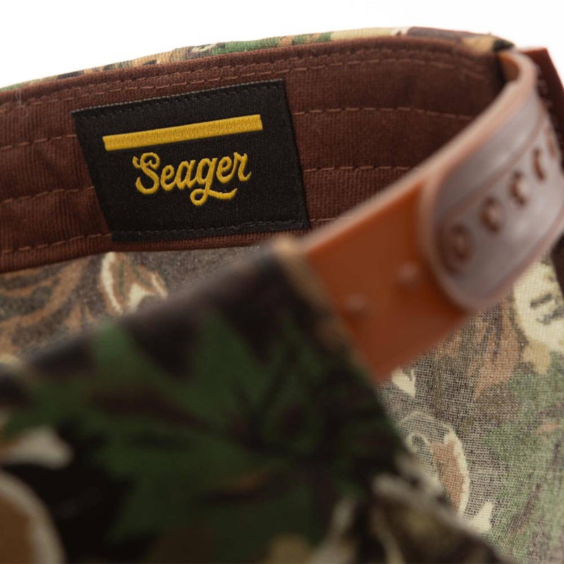 Camouflage hat with 'Seager' logo on a brown strap