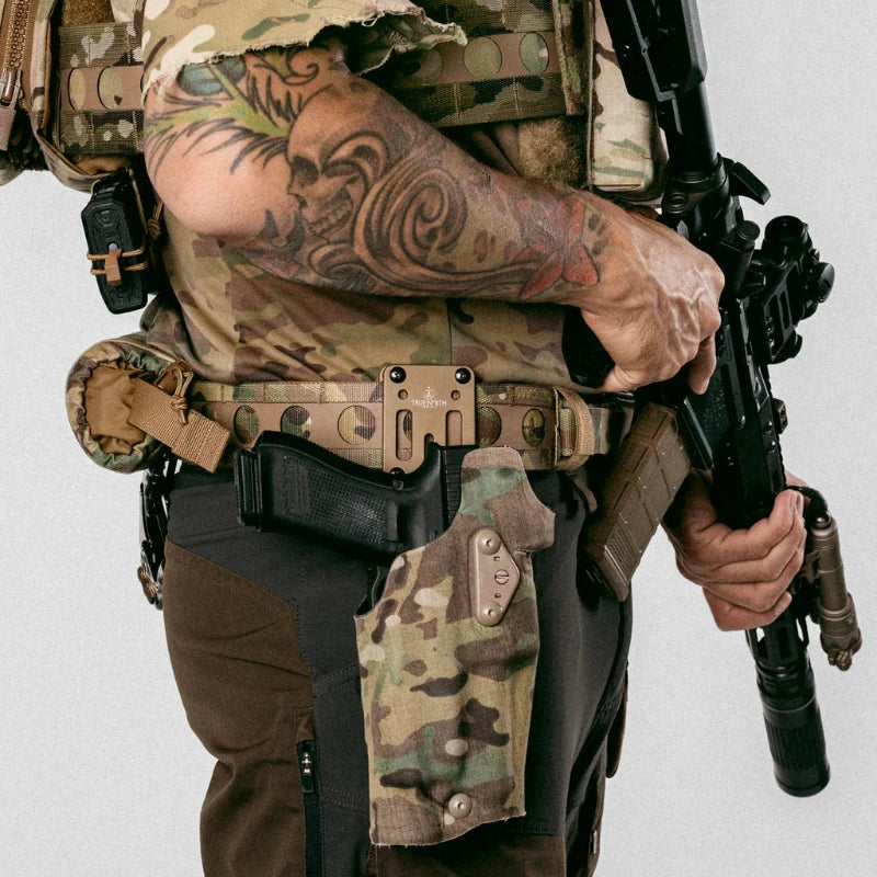 Person fully kitted out in tactical gear holding a rifle on a plain background