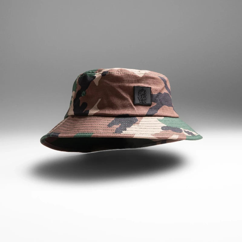 M81 Woodland Camouflage bucket hat with a Qilo x WRMFZY brand logo on a gray background