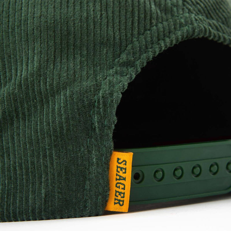 Close-up of a green corduroy product with a visible 'Seager' label.