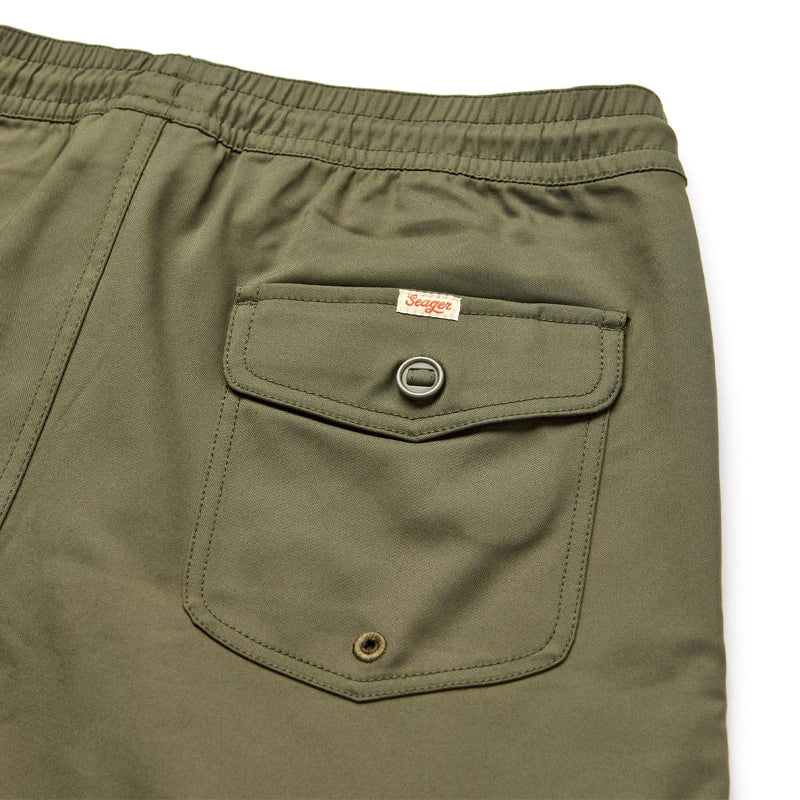 Close-up of green shorts with a pocket and brand logo on a white background