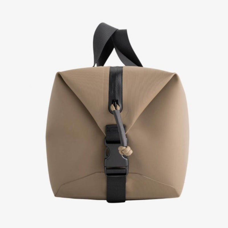 Side view of Magpul DAKA Takeout Large Bag in Flat Dark Earth (FDE) showing side-release clip | 8.88L waterproof tactical storage bag, durable RF-welded seams, and heavy-duty build — one of the best range bags for field gear.