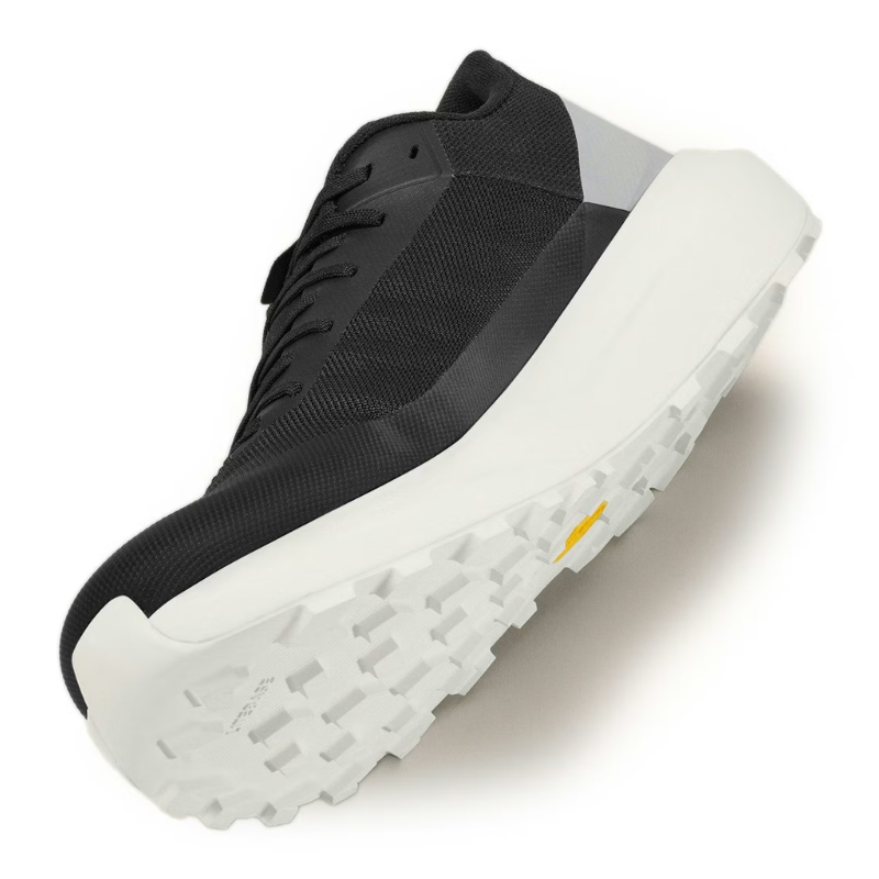 Black sneaker with white sole on a light gray background