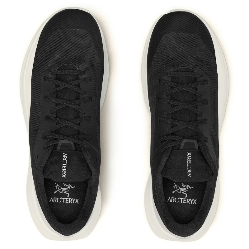 Black sneakers with white soles on a white background, featuring the Arc'teryx logo.