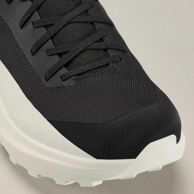 Black sneaker with white sole on a light gray background