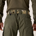 Close-up rear view of a person wearing olive green tactical cargo pants with a Multicam camouflage belt and a small black brand tab on the back waistband.