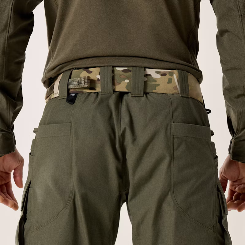 Close-up rear view of a person wearing olive green tactical cargo pants with a Multicam camouflage belt and a small black brand tab on the back waistband.