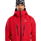 Close up view of the Arc'teryx Alpine Guide Jacket in Dynasty II red showing the chest pockets, radio ready storage, and professional ski guide GORE TEX PRO construction featured in the Arc'teryx on sale collection.