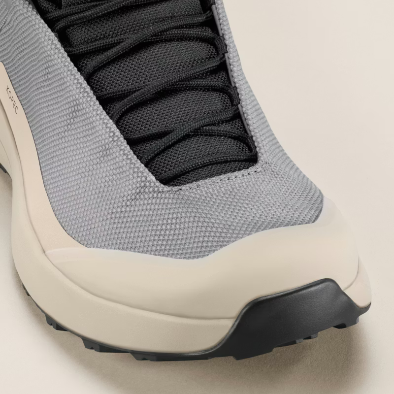 Close-up of a gray and beige boot with black sole on a light background