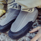 Arc'teryx Kragg Shoe worn outdoors around camp, highlighting the collapsible heel and comfortable slip-on design for post-hike and post-climb recovery.