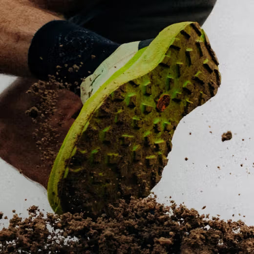 Runner wearing the Arc'teryx Norvan LD 4 on a dirt trail, highlighting long-distance comfort, stability, and all-terrain traction.