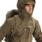 Close up view of the Arc'teryx PRO Alpha LT Jacket Gen 2.2 in Crocodile being worn with the hood up, showing the fixed hood design, weatherproof GORE TEX 3 layer fabric, and streamlined tactical fit. This PRO-series shell, evolved from the former Arc'teryx LEAF line, is engineered for wet weather operations, visibility management, and high mobility field performance.