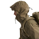 Side view of the Arc'teryx PRO Alpha LT Jacket Gen 2.2 in Crocodile worn with the hood up, highlighting the fixed hood design, streamlined military fit, and lightweight GORE TEX 3 layer protection. This PRO-series shell, evolved from the Arc'teryx LEAF line, is built for wet weather tactical movement and high mobility field performance.