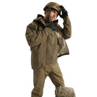 Lifestyle image of the Arc'teryx PRO Alpha LT Jacket Gen 2.2 in Crocodile being worn in a tactical environment, showing the lightweight GORE TEX 3 layer shell, military fit patterning, and low profile design originally developed under the Arc'teryx LEAF program. Demonstrates real world performance for wet weather operations, field movement, and mission ready applications.