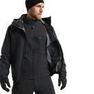 Arc'teryx PRO Atom LT Gen 2.1 in Black worn beneath a waterproof shell jacket, lightweight tactical insulation layer built for modular cold weather systems, moisture management, and professional field operations in wet conditions