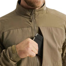 Close-up of the Arc'teryx PRO Practitioner AR Jacket in Crocodile showing the front chest pocket being used. Highlights the secure zip pocket design, Fortius Air 50 shell, and low-profile tactical storage ideal for mission essentials. Demonstrates the PRO-series mid layer’s functional access and field-ready utility for military, law enforcement, and outdoor professionals.