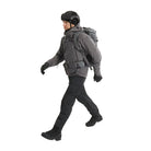 Full body view of the Arc'teryx PRO Practitioner AR Jacket in Wolf Grey being worn with a tactical backpack and load-bearing kit. Highlights how the PRO-series mid layer integrates under gear thanks to its Fortius Air 50 breathable shell and low-bulk Octa Loft insulation. Ideal for users searching how the Practitioner AR performs in real operational setups, under packs, with armor, or in high-mobility field environments.