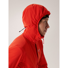 On body view of the Arc'teryx Women’s Practitioner AR Hoody in the bright Dynasty red colorway with the hood up showing the ScubaHood design on this Octa Loft insulated alpine mid layer featured in the Arc'teryx on sale collection.