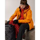 On body view of the Arc'teryx Women’s Practitioner AR Hoody in the Dynasty red colorway worn under a shell jacket showing its role as a lightweight Octa Loft insulated alpine mid layer featured in the Arc'teryx on sale collection.