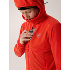 On body view of the Arc'teryx Women’s Practitioner AR Hoody in the Dynasty red colorway showing the front pocket in use and highlighting the Octa Loft insulated alpine mid layer featured in the Arc'teryx on sale collection.