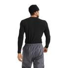 A man shown from behind wearing a black long-sleeve base layer performance shirt and gray athletic pants against a plain white background.