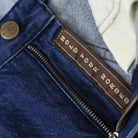 Close-up of a denim jacket with a brand label on a blurred background