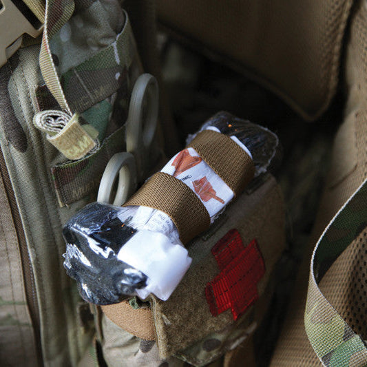 Blue Force Gear Tourniquet NOW Strap securing a CAT tourniquet to an IFAK pouch on a tactical loadout, providing rapid-access medical equipment storage and deployment.