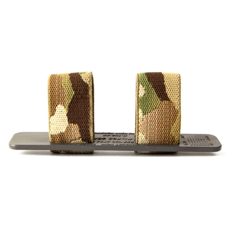 Side profile of the Blue Force Gear Tourniquet NOW Strap in MultiCam showing the low-profile molded polymer base and elastic retention loops for secure tourniquet carry.