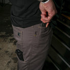 Lifestyle photo showing the Carlos Ray V3 Tactical Pants with pockets actively loaded for EDC and range prep, highlighting functional storage for tools, mags, phone, and everyday essentials while maintaining a streamlined, tactical-ready design.