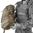 Crye Precision AVS 1000 Pack held against a plate carrier to show approximate size and profile, modular tactical assault pack compatible with Crye AVS and JPC systems designed for low profile mission ready hydration and gear carry