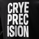 Close-up of a black garment with large white block text reading 'CRYE PRECISION'.
