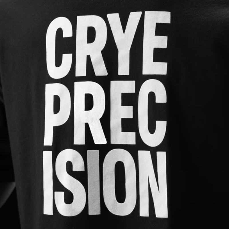 Close-up of a black garment with large white block text reading 'CRYE PRECISION'.