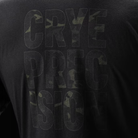 Close-up of a black T-shirt showing the back with large tonal Multicam Black camouflage text reading 'CRYE PRECISION'.