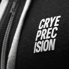Close-up of a black zippered garment with a white zipper pull and a white embroidered patch reading 'CRYE PRECISION'.