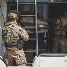 Military professional wearing plate carrier equipped with Ferro Concepts Back Panel Double Pouch during training and equipment deployment