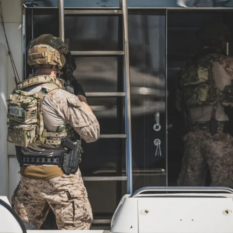 Military professional wearing plate carrier equipped with Ferro Concepts Back Panel Double Pouch during training and equipment deployment
