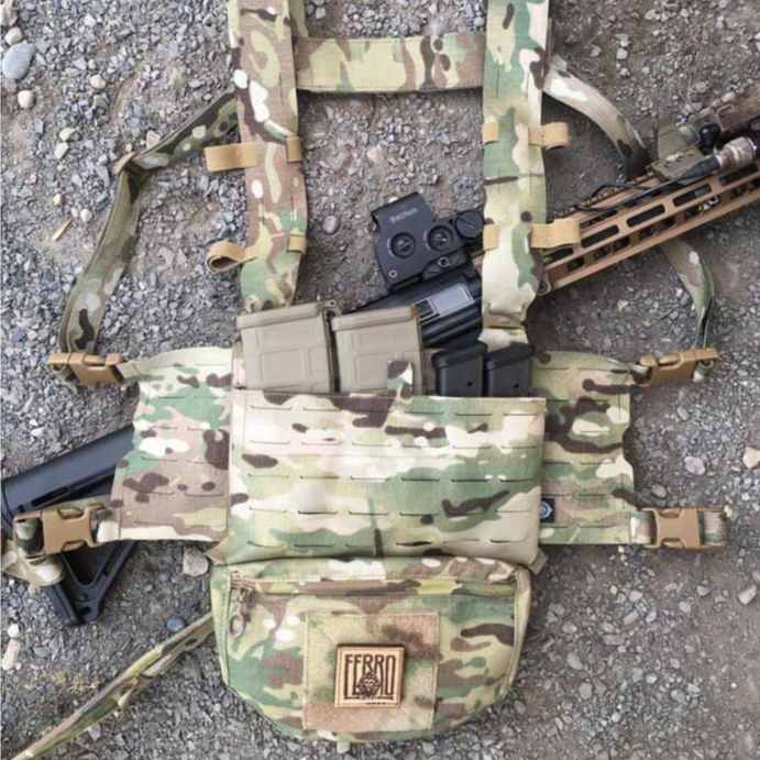 Ferro Concepts Chesty Rig Harness Wide in MultiCam shown sitting on the ground fully kitted with pouches and mags. Modular tactical chest rig harness built for Slickster and ADAPT platforms, perfect for range prep and mission loadouts.