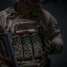 Operator accessing gear from Ferro Concepts MOLLE Admin Panel mounted on plate carrier demonstrating rapid access to tools, notes, and mission essential equipment