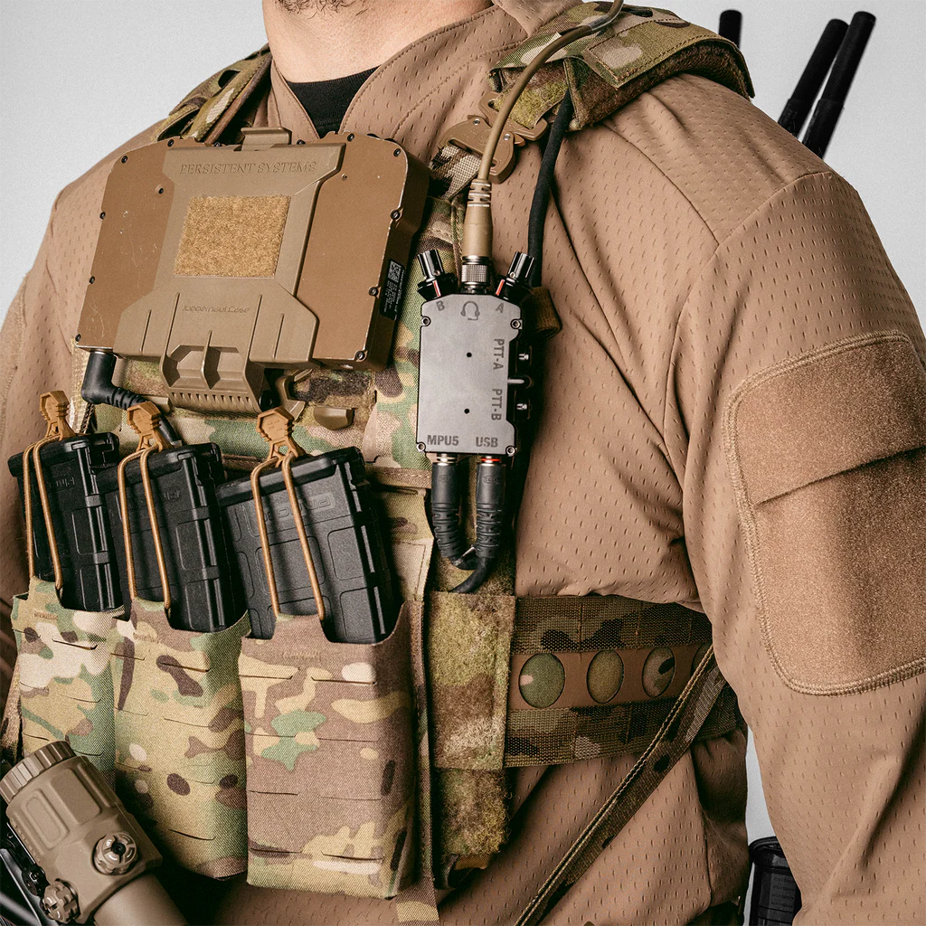 Operator using Ferro Concepts PTT Wing Kit mounted to plate carrier showing optimized Push-To-Talk placement and clean communications routing