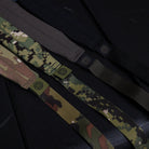 Multiple GBRS Group SBS Slings in assorted colorways laid out on a rifle case, lightweight minimalist adjustable tactical rifle slings with padded neck sections and low profile webbing for professional weapon setups made in the USA