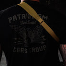 Rear view of operator wearing GBRS Group SBS Sling in two point configuration, minimalist adjustable tactical rifle sling with padded neck section mounted to rifle and worn over plate carrier for duty and range use